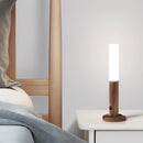 Motion Sensor LED Rechargeable Night Light featuring a wooden design, rectangular shape, and a lamp shade, placed in an interior setting.