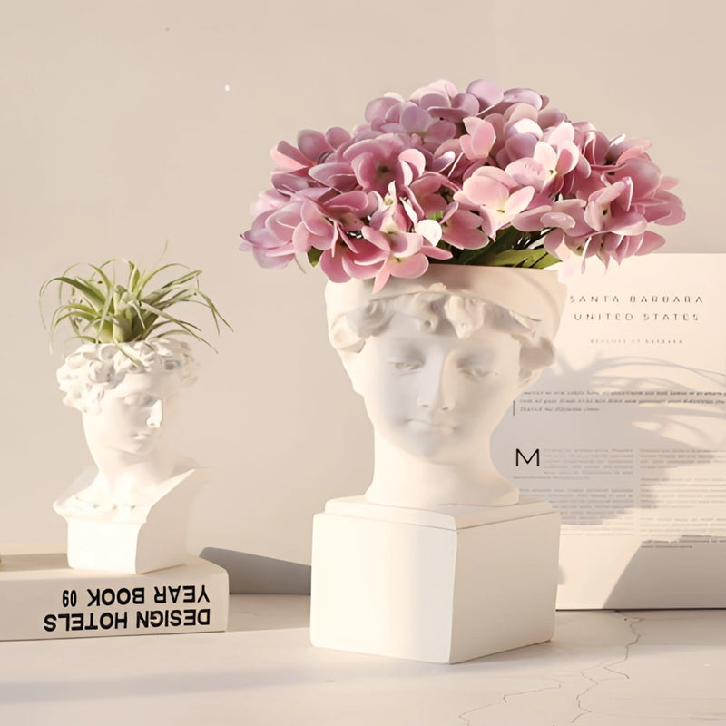 Neoclassical Greek head resin vase in white, used as a planter with vibrant houseplants and decorative flowers, showcasing creative flower arranging.