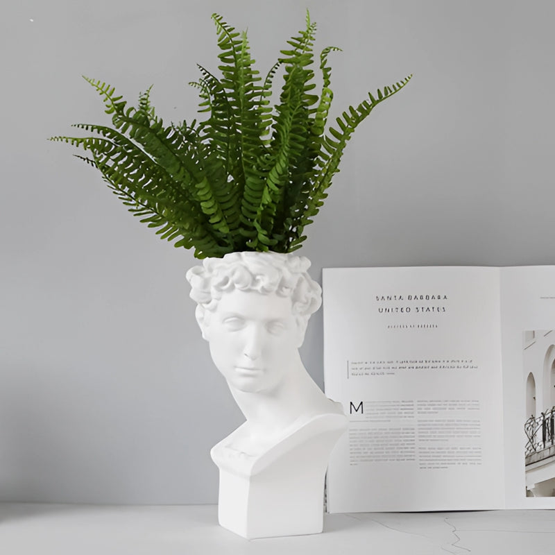 Neoclassical Greek head-shaped resin vase featuring plant and artistic sculpture elements, resembling a statue with detailed rectangular base.