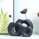 Nordic style ceramic donut vase featuring a modern circular design, displayed with a plant, emphasizing artistic and contemporary aesthetics ideal for office and living room decor.