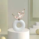 Nordic style ceramic donut vase in a modern circular design, displayed in a well-lit room enhancing the interior design aesthetic.