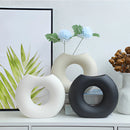 Nordic style ceramic donut vase with a circular design, resembling a wheel or tire, displaying a minimalistic and modern aesthetic for office or living room decor.