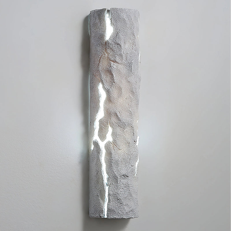 Outdoor wall light with IP65 waterproof rating, featuring a premium resin faux rock finish, designed in a cylindrical shape with glass and metal elements, depicting moisture and liquid effects.