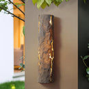 Outdoor wall light featuring IP65 waterproof rating with a premium resin faux rock finish, surrounded by green leaves and branches, incorporating natural materials and glass elements.