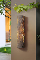 Outdoor wall light with IP65 waterproof rating, featuring a premium resin faux rock finish, surrounded by natural elements like leaves, branches, and wood textures.