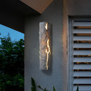 Outdoor wall light with IP65 waterproof rating, featuring a premium resin faux rock finish, mounted on a building surrounded by plants near a window.