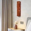 Outdoor Wall Light IP65 Waterproof with a premium resin faux rock finish, displayed against a wooden rectangle shelving near a window with curtains, featuring artistic decor and a picture frame.