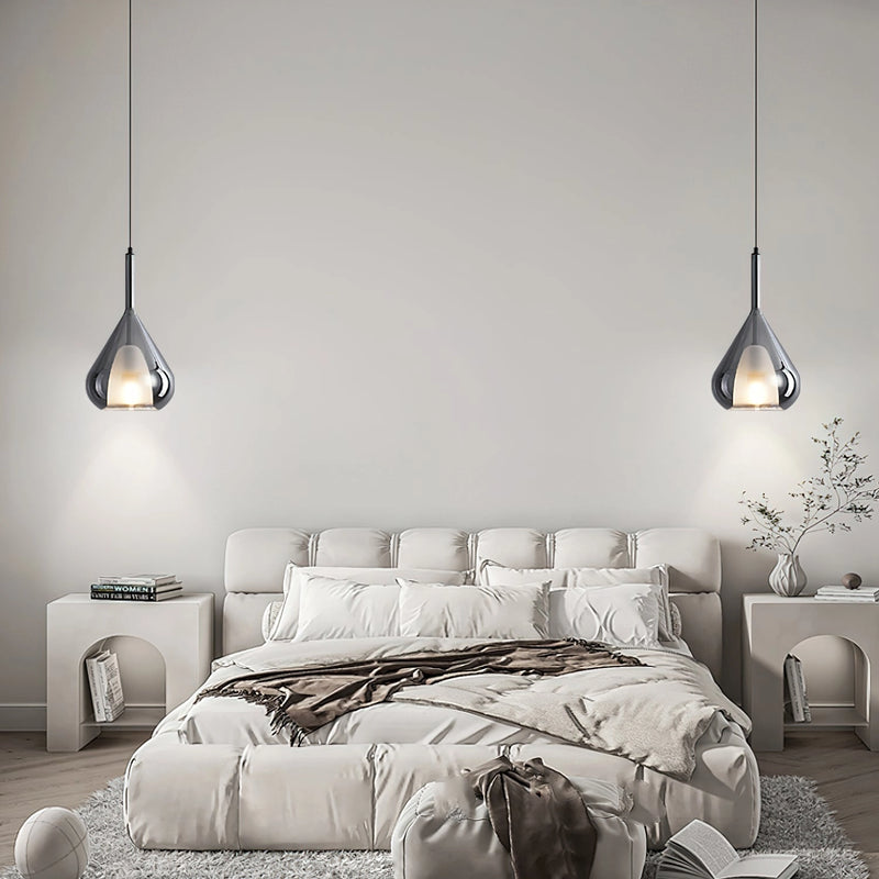 Nordic style pendant lamp featuring a clear raindrop design with a starlight effect, suspended in a room with white and black decor and wooden elements.
