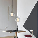 Nordic style pendant lamp featuring a clear raindrop design with starlight effect, displayed over a table in a well-designed interior with wooden elements and a chair.