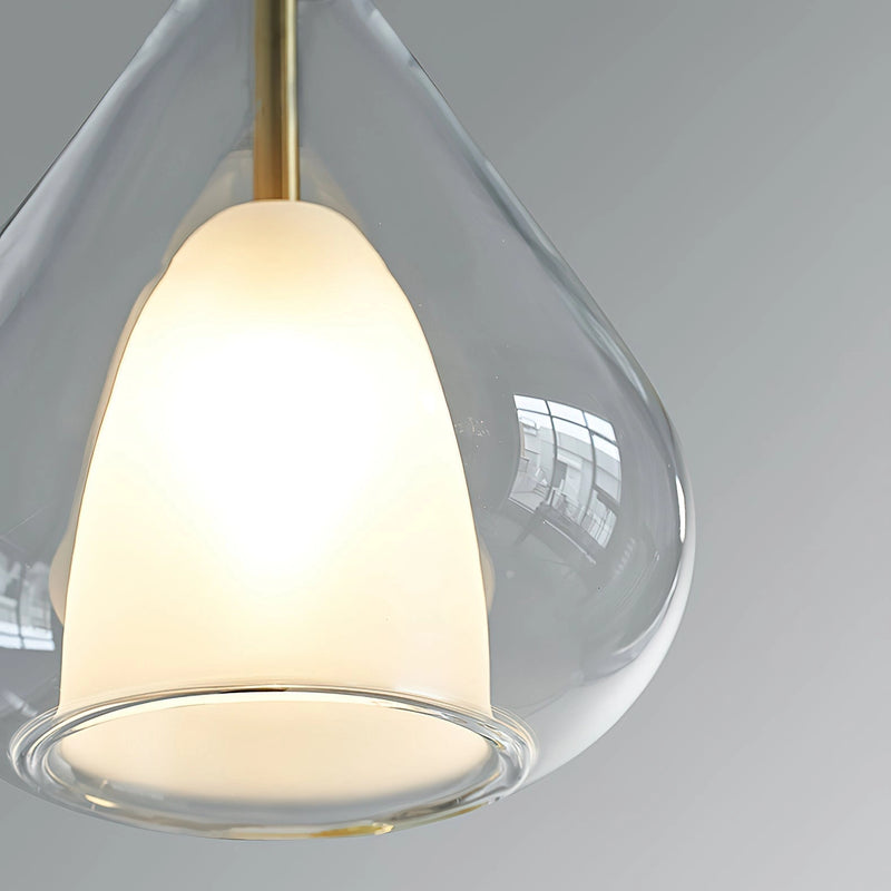 Clear raindrop-designed pendant lamp with starlight effect, featuring a metallic ceiling fixture and a circular shade in Nordic style.