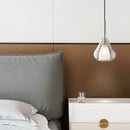 Clear raindrop design pendant lamp with starlight effect, featuring a Nordic style with wood accents, situated in a room with light grey decor and rectangular floor lines.