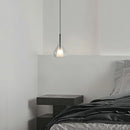 Nordic style pendant lamp featuring a clear raindrop design with a starlight effect, displayed in a room with grey walls, wooden flooring, and comfortable shades.
