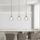 Nordic style pendant lamp with a clear raindrop design and starlight effect, displayed above a wooden table in a room with grey furniture and flooring.