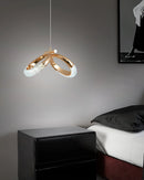 Modern Dante pendant lamp featuring a rectangular black and white chandelier above a grey couch, set against a wood-accented wall.