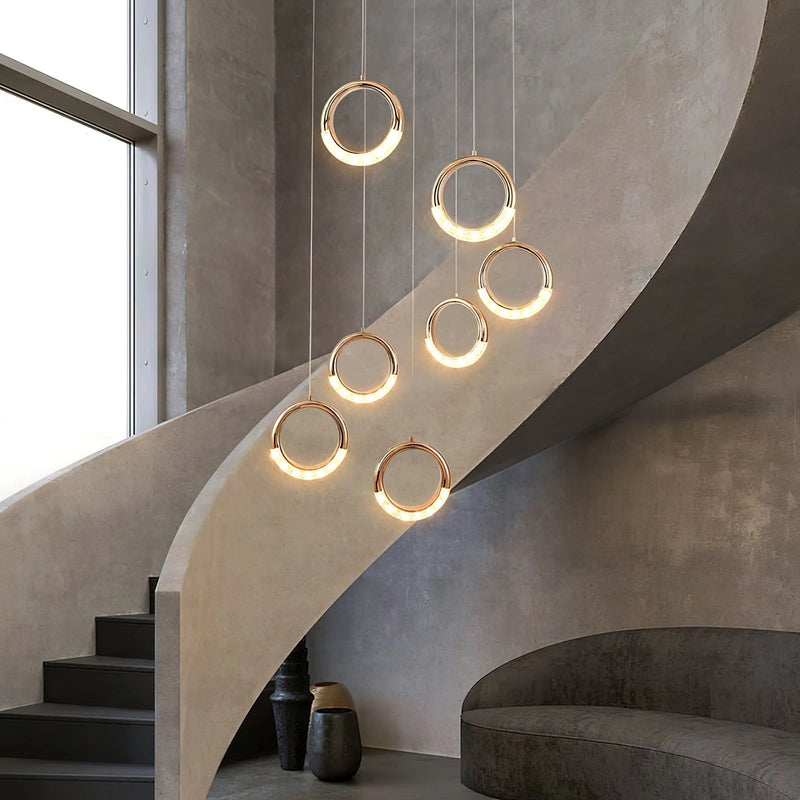 Modern Dante pendant lamp featuring a wooden chandelier design, artistic sculpture elements, and stylish shades, installed in an interior setting with stairs and a detailed ceiling.