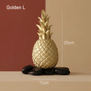 Golden resin ornament in the shape of a pineapple, designed for Nordic home decor, displayed on a wooden surface.