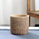Large rattan cement planter with natural texture, without a tray, displayed on a wooden surface.