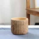 Medium-sized rattan cement planter with natural texture, displayed without a tray on a hardwood floor.