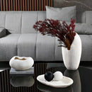 Resin nature-inspired decorative bowl displayed on a rectangular table in a stylish interior setting with a white and black color scheme.