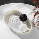 Decorative resin bowl inspired by nature, featuring intricate designs that resemble bird feathers and wings, crafted from natural materials and styled with a circular shape.