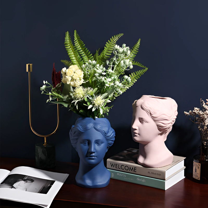Neoclassical Venus vase made from resin, featuring sculptural details and used for flower arranging, available in blush pink, teal, and grey colors.