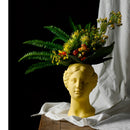 Resin Neoclassical Venus Vase featuring a sculpture of Venus adorned with a bouquet of artificial flowers and petals in a flower arranging art style.