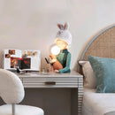 Resin table lamp featuring an elegant rabbit girl design with dual glass lampshades, placed on a wooden table, enhancing the interior design of the room.