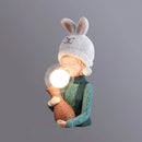 Resin table lamp featuring an elegant rabbit girl design with a dual glass lampshade, detailed with human-like features such as head, hands, arms, and eyes, dressed in attire with sleeves and headgear, in white variant size 3.1″ x 5.1″ x 12.2″.