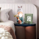 Resin table lamp featuring an elegant rabbit girl design with dual glass lampshades, set against a comfortable interior backdrop with wooden elements and artistic wall decor.