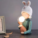 Resin table lamp featuring an elegantly designed rabbit girl with a dual glass lampshade, adorned with a costume hat and positioned on a wooden base.