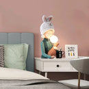 Resin table lamp featuring an elegant rabbit girl design with dual glass lampshades, set on a wooden rectangular table in a comfortably designed interior.