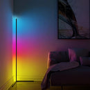 RGB corner floor lamp with LED lights illuminating a room with purple light, near a couch, showcasing a modern interior design with wooden flooring.