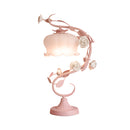 Elegant rose encased table lamp featuring a metal lampshade and ornamental design, ideal for enhancing home decor.
