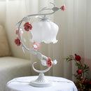 Elegant table lamp featuring a red rose encased in clear glass, with delicate twigs and petals, enhancing an artistic and floral interior design.