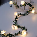 Battery-operated LED garland featuring white rose flower string lights, creatively arranged on branches and twigs for decoration.
