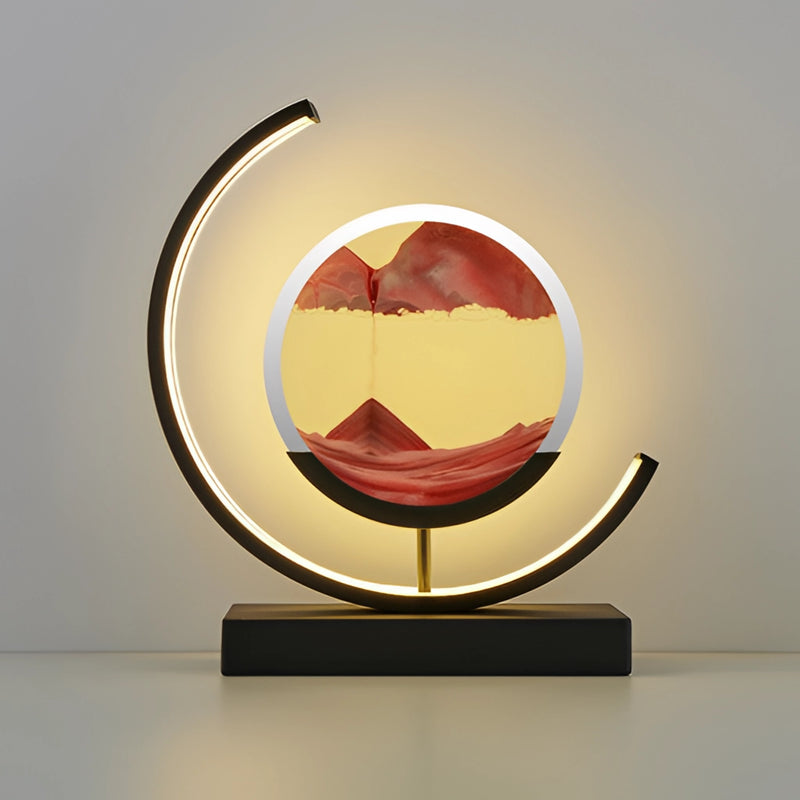 Dynamic 3D sand painting light featuring a red and black sand art LED table lamp, with a metal emblem and an oval-shaped logo in a circular design.