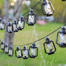 Outdoor solar string lights with LED lanterns in RGB and white colors, displayed over a lush green garden setting with grass, trees, and plants, showcasing their waterproof and decorative features.