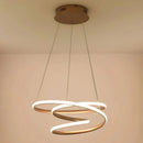 Elegant spiral pendant light crafted from aluminum, featuring a modern design with warm illumination, suspended from a wooden ceiling.