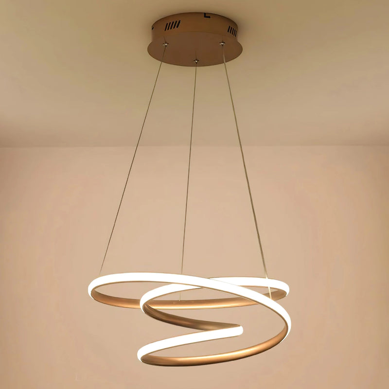 Elegant spiral pendant light crafted from aluminum, featuring a modern design with warm illumination, suspended from a wooden ceiling.