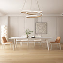 Elegant spiral pendant light with warm illumination hanging over a modern interior including a table, chairs, and plants, with wooden flooring and beige decor.