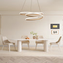Spiral pendant light with warm illumination hanging above a modern interior setting, featuring a table, chair, plant, and wooden flooring.