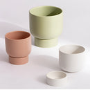 Ceramic vase designed as a stacked flower pot for garden and bonsai use, resembling a collection of coffee cups and teacups in various sizes, crafted in porcelain on a table.