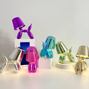 Purple and violet balloon dog-designed table lamp with a touch-sensitive, dimmable crystal base, displayed on a table.