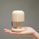 Dimmable ivory table lamp with a touch switch, featuring a human finger poised to adjust the setting.