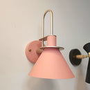 Elegant retro design interior wall light with a matt pink finish, featuring a circular metal and wood light fixture.