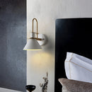 Elegant retro design wall light with matt finish, featuring a rectangular metal and wood lamp mounted above a couch in a stylishly decorated room with art and linens.