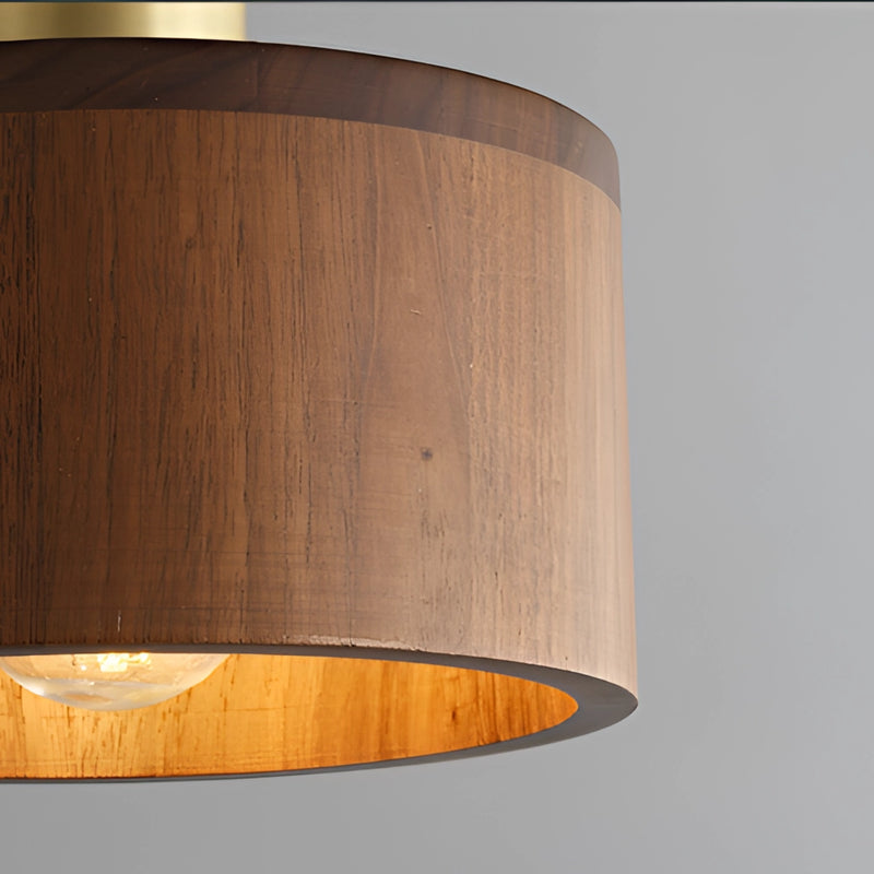 Walnut wood pendant lamp inspired by Japanese woodworking, featuring a cylindrical shade made from layers of stained hardwood and plywood, creating a warm, ambient light.