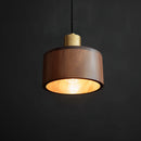 Walnut wood pendant lamp inspired by Japanese woodworking, featuring a rectangular shade with a combination of metal and wood elements, emitting a soft light.