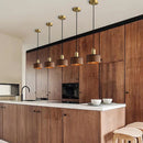 Walnut wood pendant lamp inspired by Japanese woodworking, hanging in a stylish kitchen with visible cabinetry and countertops.