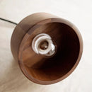 Walnut wood pendant lamp inspired by Japanese woodworking, featuring a circular wooden design resembling a wheel, suspended from the ceiling.